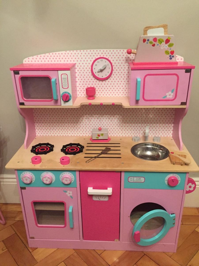 pink wooden kitchen with washing machine